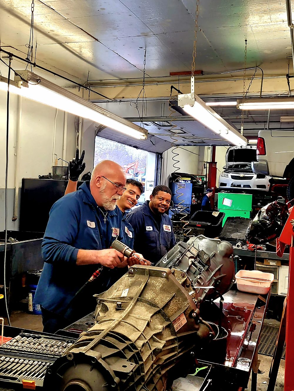 Two technicians rebuilding a transmission at the bench
