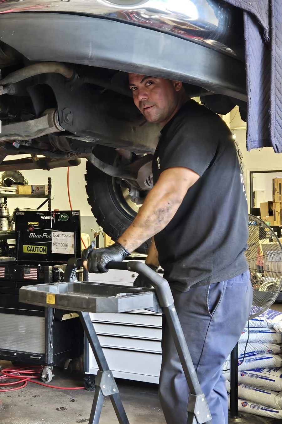 A technician working underneath a vehicle